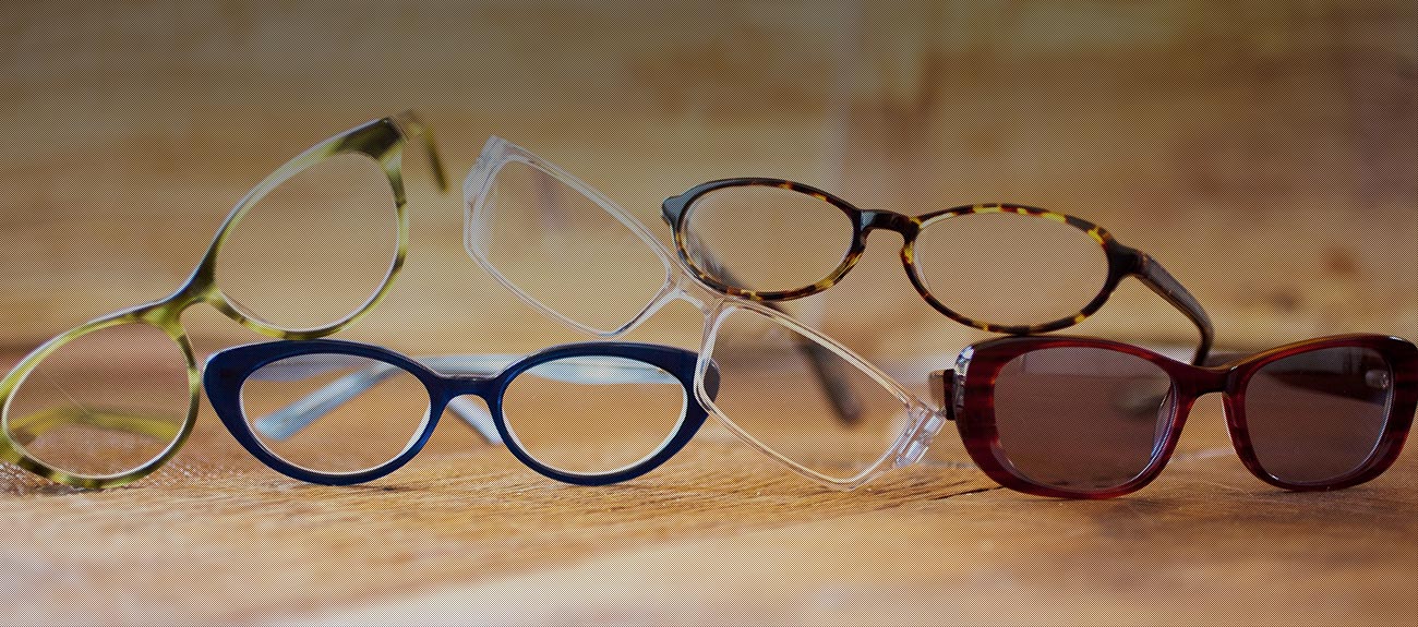 Five pairs of glasses in a pile on a table