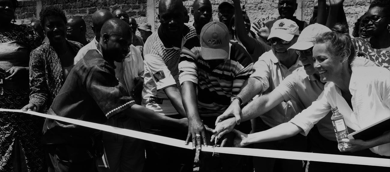 Group of people cutting ribbon in a launch ceremony 