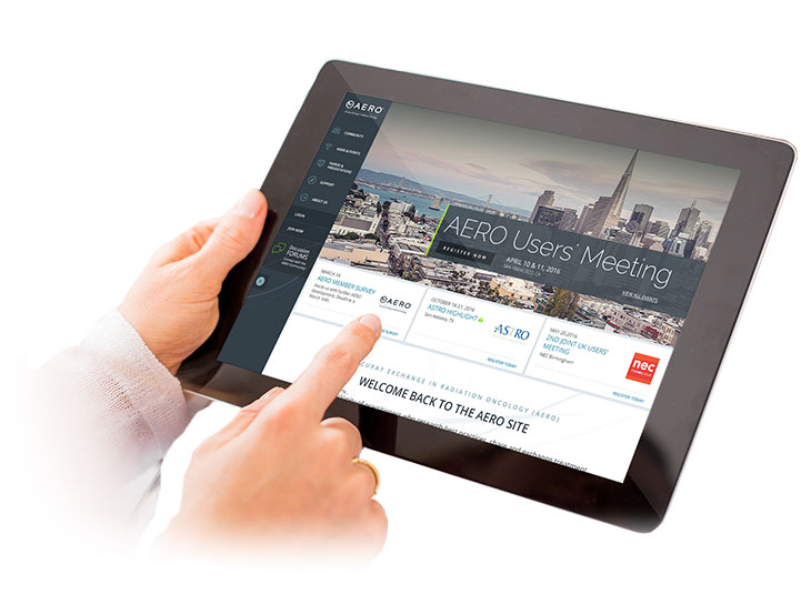 Hands holding a tablet pointing to a screen showing Accuray's clinical forum